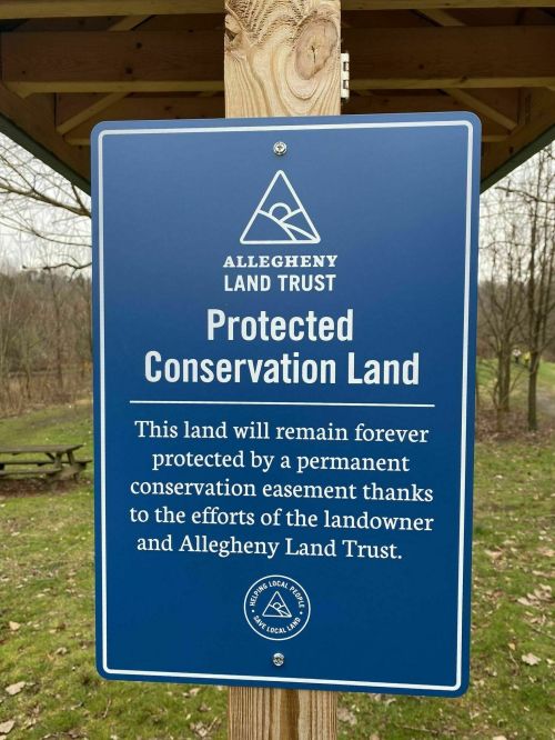 Sign indicating protected conservation land by Allegheny Land Trust, highlighting permanent conservation efforts.