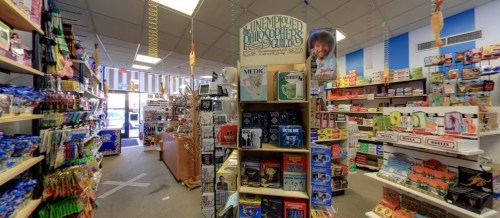 A colorful store interior filled with shelves of toys, games, and novelty items, featuring a display of philosophy books.