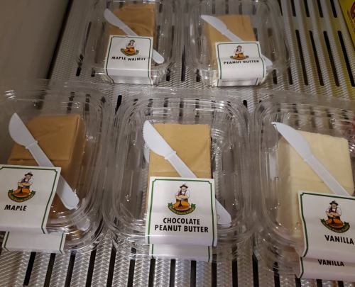 Five containers of fudge labeled: Maple Walnut, Peanut Butter, Chocolate Peanut Butter, Vanilla, and Maple.