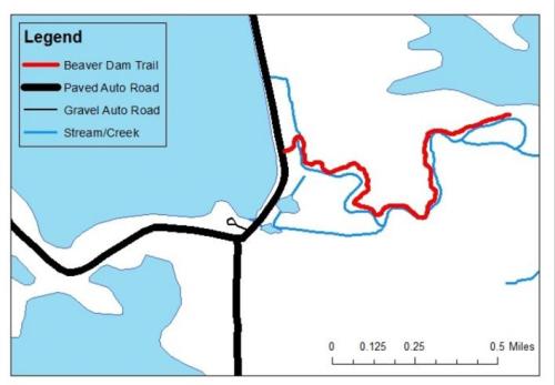 Map showing Beaver Dam Trail in red, paved auto road in black, gravel auto road, and stream/creek in blue.