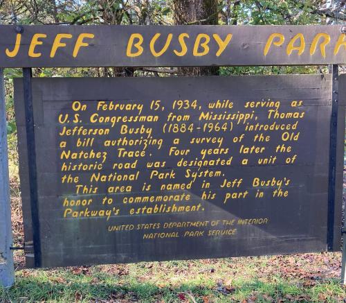 Sign at Jeff Busby Park detailing Thomas Jefferson Busby's role in designating the Old Natchez Trace as a national park.
