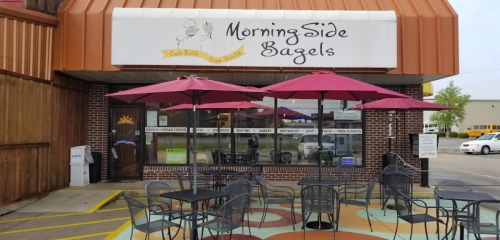 Exterior of MorningSide Bagels with outdoor seating and umbrellas, featuring a sign above the entrance.