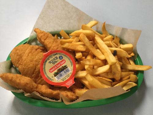 A green tray with crispy fried fish fillets, golden French fries, and a container of sweet dipping sauce.