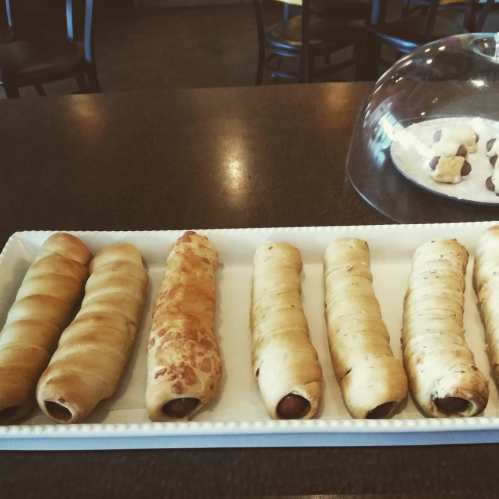 A tray of baked pastries filled with chocolate, arranged neatly on a table.