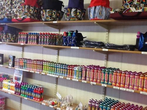 A store shelf displaying colorful bottles, bags, and various products arranged neatly.