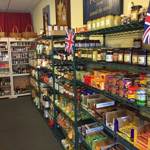 A grocery store aisle filled with shelves of various food products, including jars, snacks, and British flags.