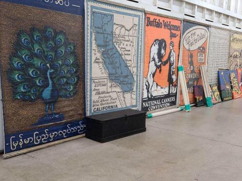 A collection of colorful posters and signs displayed on a wall, featuring various designs and messages.
