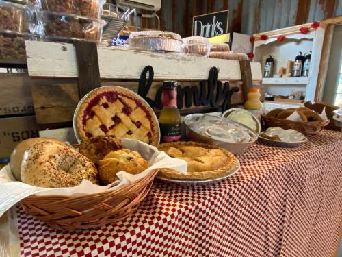 A rustic display of baked goods, including pies, bread, and pastries, on a checkered tablecloth with a "family" sign.