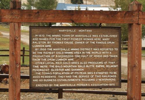 Sign about Marysville, Montana, detailing its mining history and population in 1970, with a wooden frame.