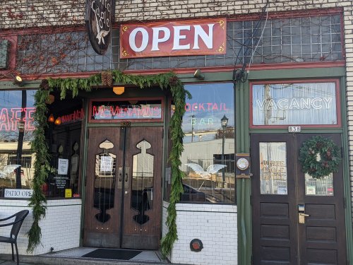 A storefront with "OPEN" sign, festive decorations, and a "VACANCY" sign on the door.