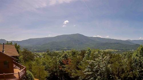 Scenic view of mountains and lush greenery under a clear blue sky.