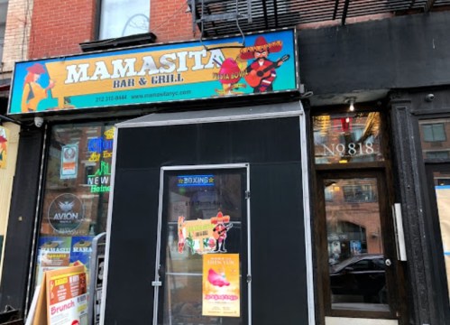 Exterior of Mamasita Bar & Grill, featuring a colorful sign and entrance with promotional posters.