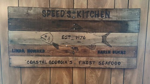 Wooden sign for Speed's Kitchen, established 1976, featuring a fish illustration and the tagline "Coastal Georgia's Finest Seafood."