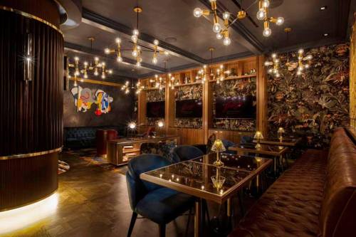 A stylish lounge with elegant lighting, plush seating, and artistic decor, creating a cozy and sophisticated atmosphere.
