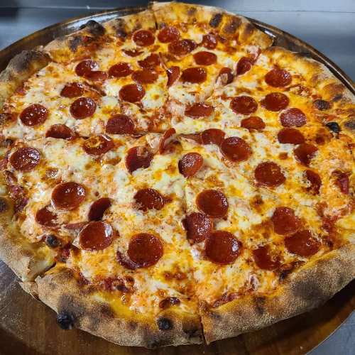 A freshly baked pepperoni pizza with melted cheese and a golden crust, served on a wooden pizza board.