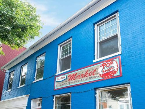 Bright blue building with a sign reading "North Market" and "Pop Shop" featuring ice cream and hot dogs.