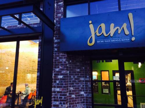 Exterior of a restaurant named "jam!" with a modern design, featuring large windows and a brick facade.