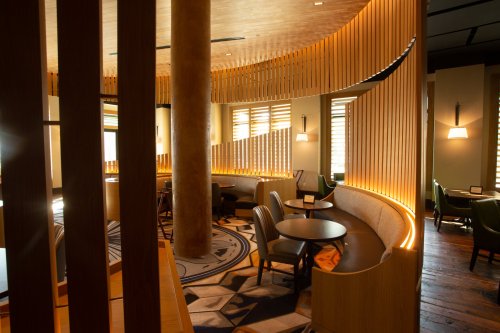 Cozy restaurant interior featuring wooden accents, soft lighting, and comfortable seating arrangements.