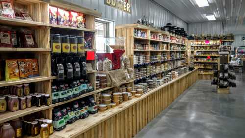 A well-organized store interior with wooden shelves filled with jars, snacks, and various food products.