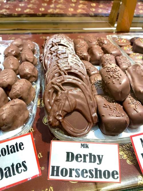 A display of chocolate treats, including chocolate dates and Derby horseshoe-shaped candies, all coated in chocolate.