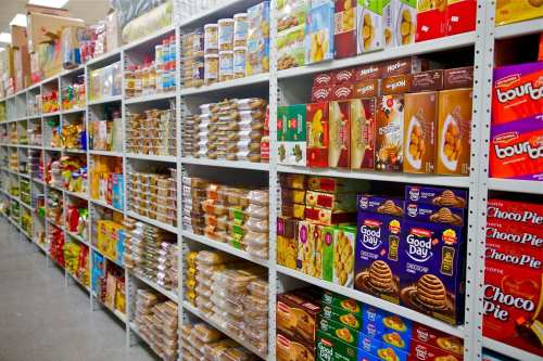 A grocery aisle filled with shelves of various packaged snacks and food items.