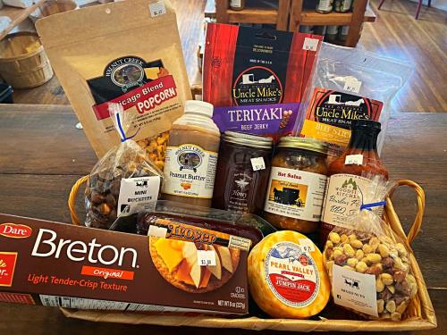 A basket filled with snacks including popcorn, beef jerky, peanut butter, salsa, and assorted treats.