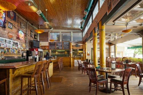 Cozy restaurant interior with wooden bar, tables, and a vibrant atmosphere, featuring a chalkboard menu and bar taps.
