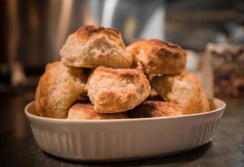A plate of golden-brown, freshly baked biscuits stacked neatly.