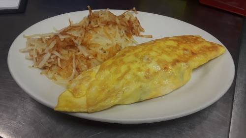 A plate with a fluffy omelet and a side of crispy hash browns.