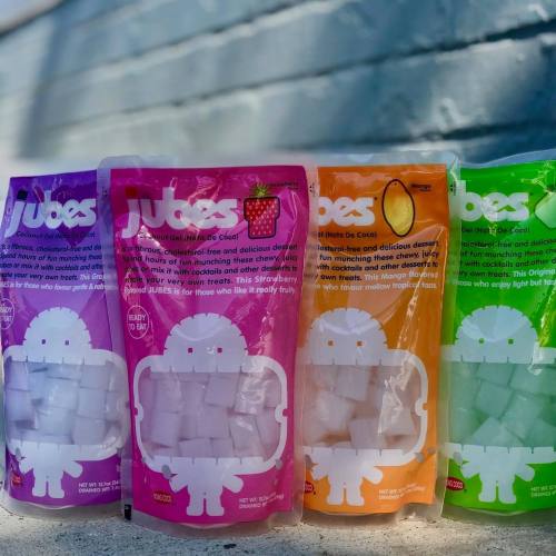 Four colorful packages of JUJUBES candy, featuring strawberry and lemon flavors, displayed against a light background.