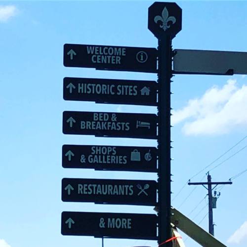 Signpost with directional arrows for various attractions: Welcome Center, Historic Sites, Bed & Breakfasts, Restaurants, and more.