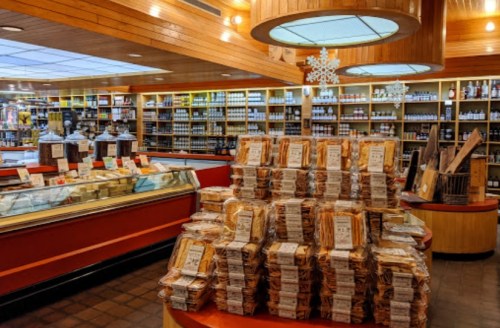 A cozy store interior filled with stacked packages of goods and shelves lined with jars and products.
