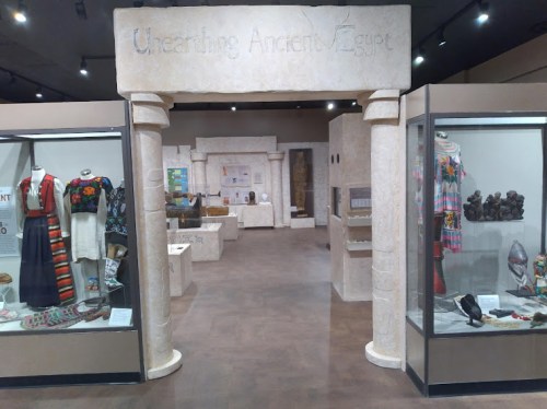 Exhibit entrance titled "Unearthing Ancient Egypt," showcasing artifacts and displays in a museum setting.