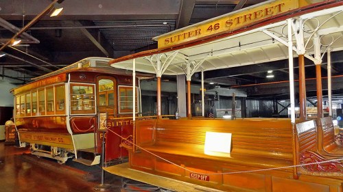 Historic cable car on display, featuring "Sutter 46 Street" signage and vintage wooden seating.