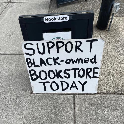 A sidewalk sign reads "Support Black-owned Bookstore Today" in bold letters.