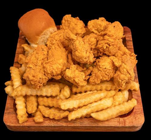 A wooden platter filled with crispy fried chicken, crinkle-cut fries, and a soft dinner roll.