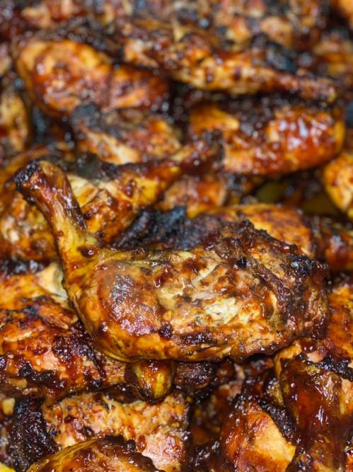 A close-up of grilled chicken pieces with a crispy, charred exterior and a glossy glaze.