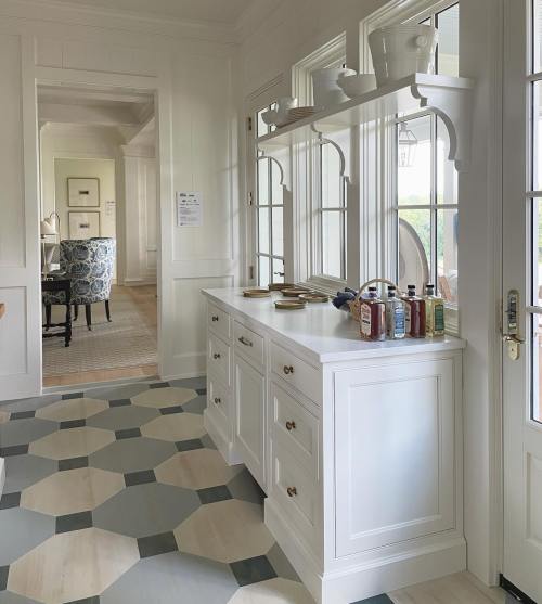 Bright, modern kitchen with white cabinetry, a patterned floor, and large windows letting in natural light.