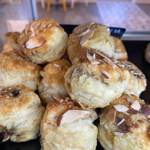 A close-up of freshly baked scones topped with sliced almonds and sprinkled with sugar.