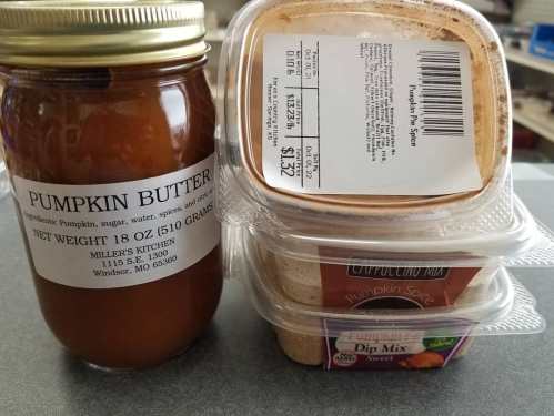 A jar of pumpkin butter next to two containers of dip mix, all on a countertop.