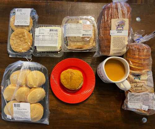 A variety of baked goods including cookies, bread, and a sandwich on a red plate, with a cup of coffee.