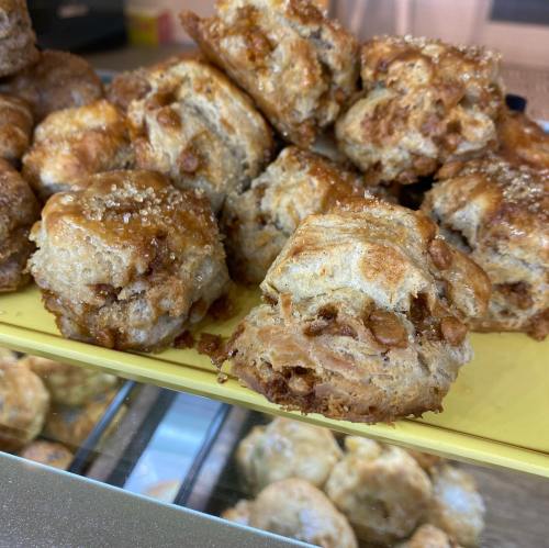 A close-up of freshly baked pastries with a golden-brown crust and a sprinkle of sugar on top.