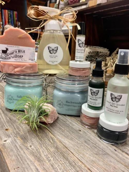 A display of handmade skincare products, including soaps, lotions, and sprays, arranged with decorative elements.