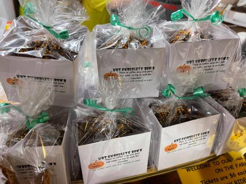 Bags of hot chocolate bombs wrapped in clear plastic, displayed on a table with a festive label.