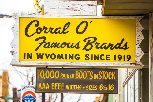 Sign for Corral O' Famous Brands, established in Wyoming since 1919, advertising 10,000 pairs of boots in stock.