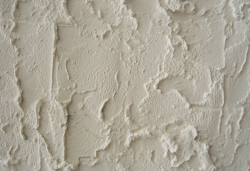 Textured white wall with a rough, uneven surface and subtle variations in tone.