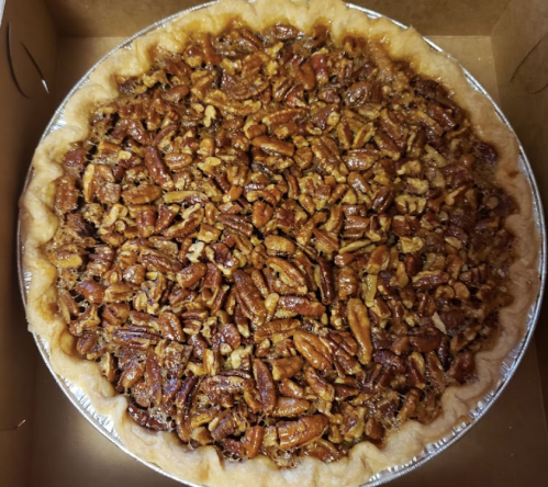 A freshly baked pecan pie with a golden crust and a rich filling topped with whole pecans.