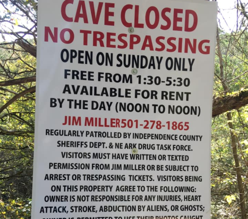 Sign indicating cave closure, no trespassing, open Sundays 1:30-5:30, available for rent, contact info provided.