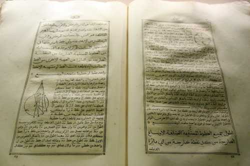 Open pages of an ancient Arabic manuscript featuring handwritten text and diagrams on scientific concepts.