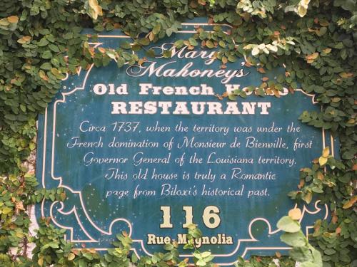 Sign for Mary Mahoney's Old French House Restaurant, detailing its history and location at 116 Rue Magnolia.